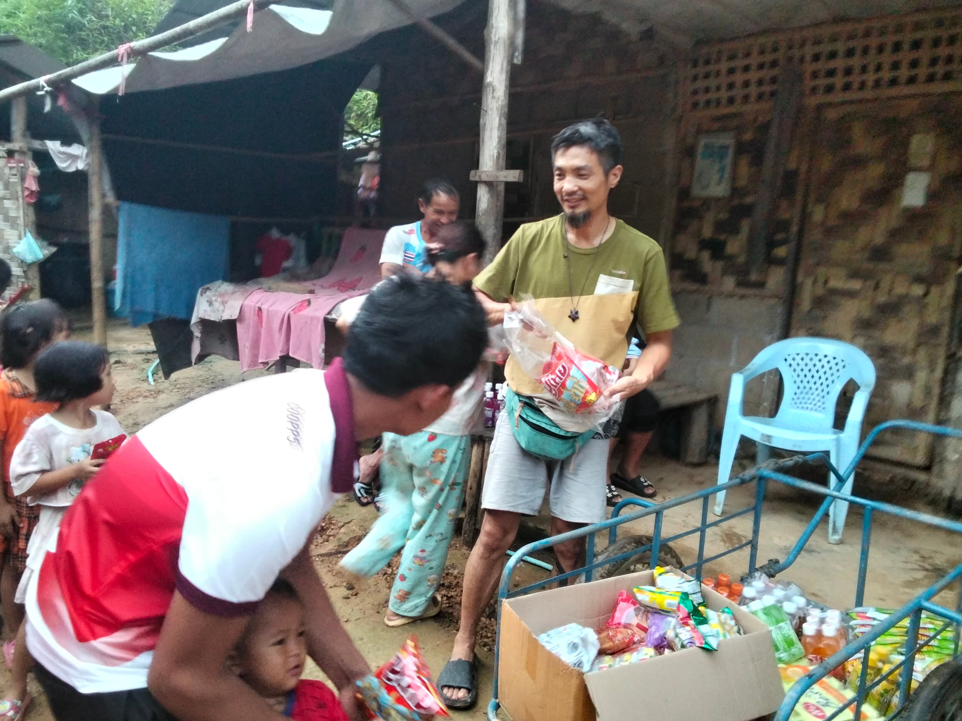 A volunteer handing out supplies to families during a visit to the village.